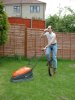 Real men mow the lawn riding a unicycle and drinking beer